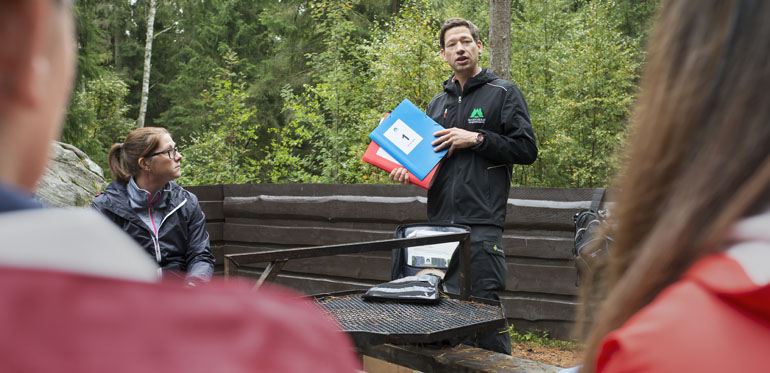 Skogskonsulent Daniel Thorell undervisar lärarstudenter i hur de kan använda skolskogsryggsäckarna i deras undervisning vid en skogsdag. Foto: Julia Sjöberg